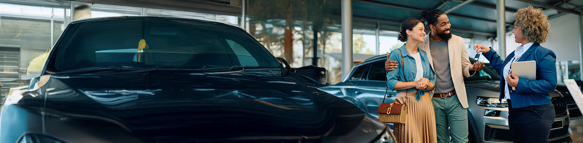 Service Suite, a service advisor handing keys to customers on the showroom floor